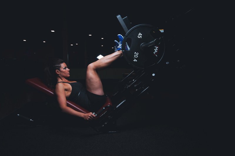 Eine Frau trainiert ihre Beine mit Gewichten