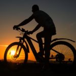 Mann auf E-Moutainbike Offroad im Sonnenuntergang