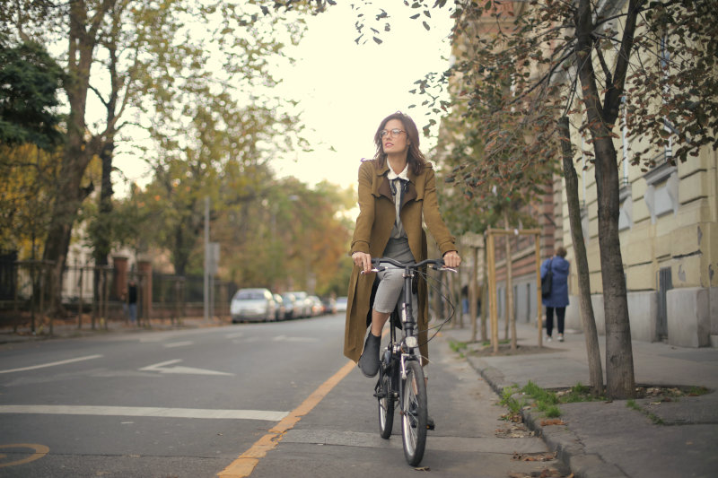 Eine Frau fährt mit ihrem E-Bike-Faltrad im alltäglichen Straßenverkehr