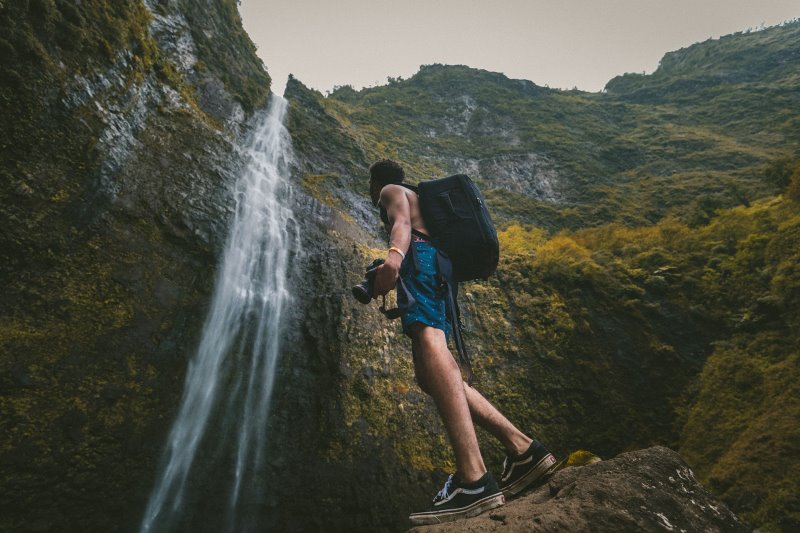 Mann am Wasserfall mit wasserdichten Rucksack