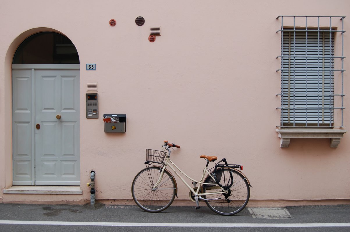 Ein Tourenrad mit Fahrradkorb und Gepäckträger vor einer Hauswand