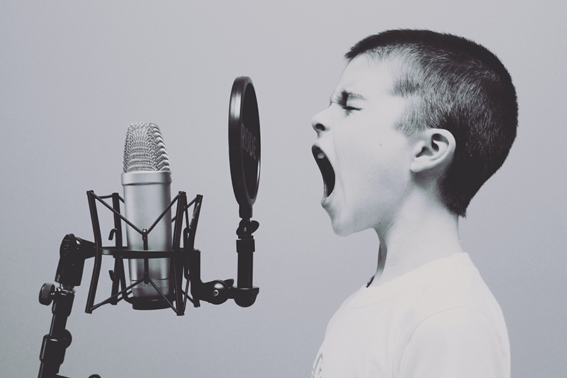 Junge singt vor einem Mikrofon