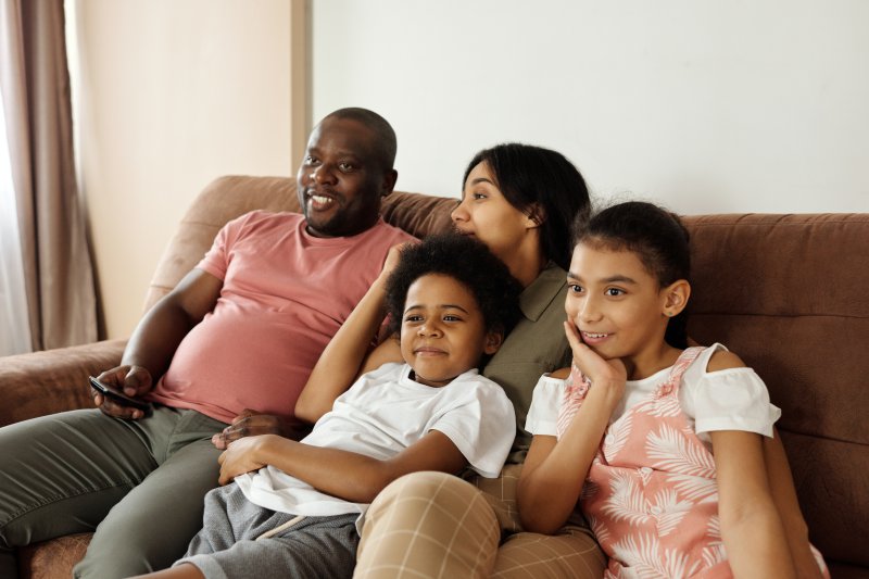 Familie, die mit Universalfernbedienung ihren Smart-TV steuert. 