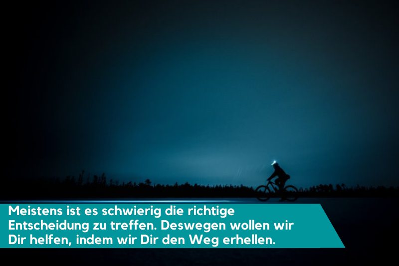 Ein*e Fahrradfahrer*in benutzt seine/ihre Kopflampe fürs Fahrrad fahren bei Nacht