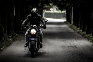 Mann in schwarzer Motorradbekleidung auf Motorrad